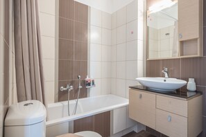 A modern bathroom with a bathtub, a sink, and a toilet. - Elegant Home with Balcony by CloudKeys (Athens)