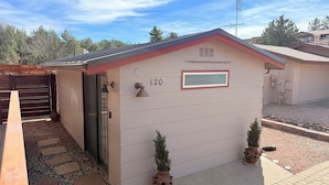 A small, single-story building with a red roof and beige siding, marked with the number 120. - A Beautiful Cozy Cottage in West Sedona (Sedona)