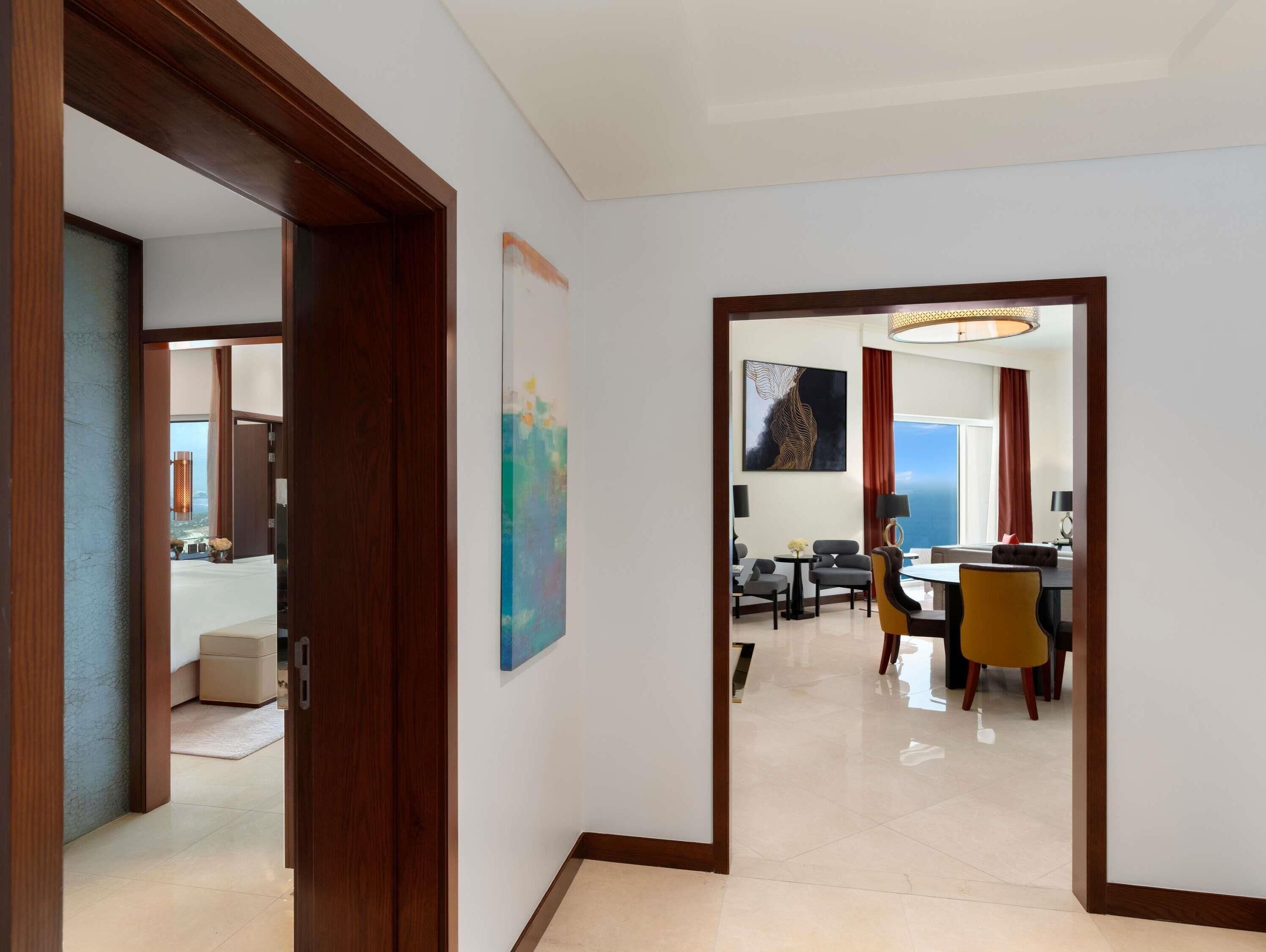 A hotel hallway leading to a dining area with a view of the sea.