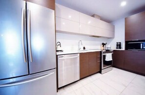 Fully equipped kitchen with a refrigerator, dishwasher, oven, microwave, and coffee maker.
