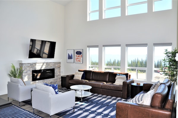Large, cozy living room features extra high ceilings and unobstructed views