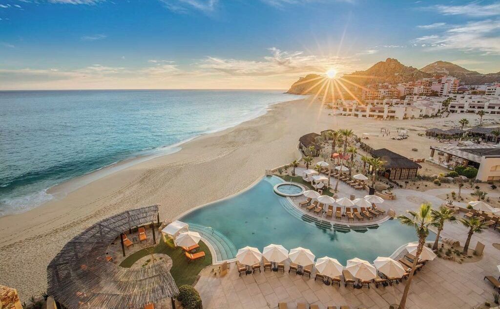 A resort with a pool, beach, and mountain views.