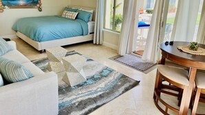 Una camera da letto con un letto, un divano, un tavolo da pranzo e vista sull'esterno.