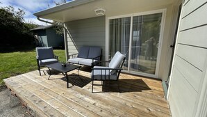 A deck with outdoor furniture, a sliding glass door, and a covered area with a roof.