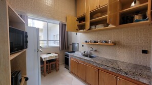 Enjoy meals in this kitchen with a stove, sink, and microwave, and dine at the nearby table with a view of the outside.