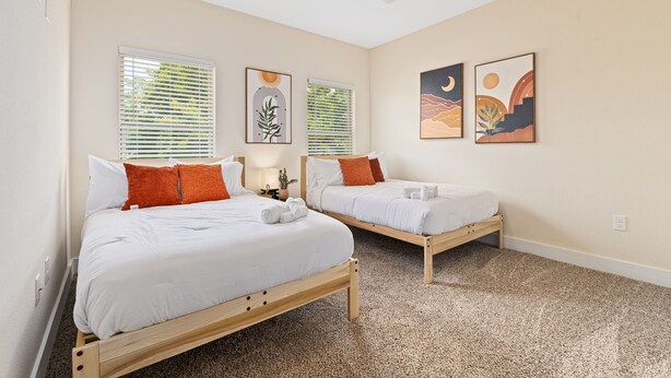 A bedroom with two single beds, a ceiling fan, and artwork on the walls. - Spacious Modern Chic 5BR Home in Dallas - 9 Beds! (Dallas)