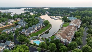 Un quartier résidentiel avec des maisons, une piscine et une rivière.