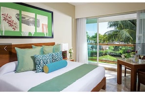 Relax in a serene space with a large bed, lush garden views, and a pool.