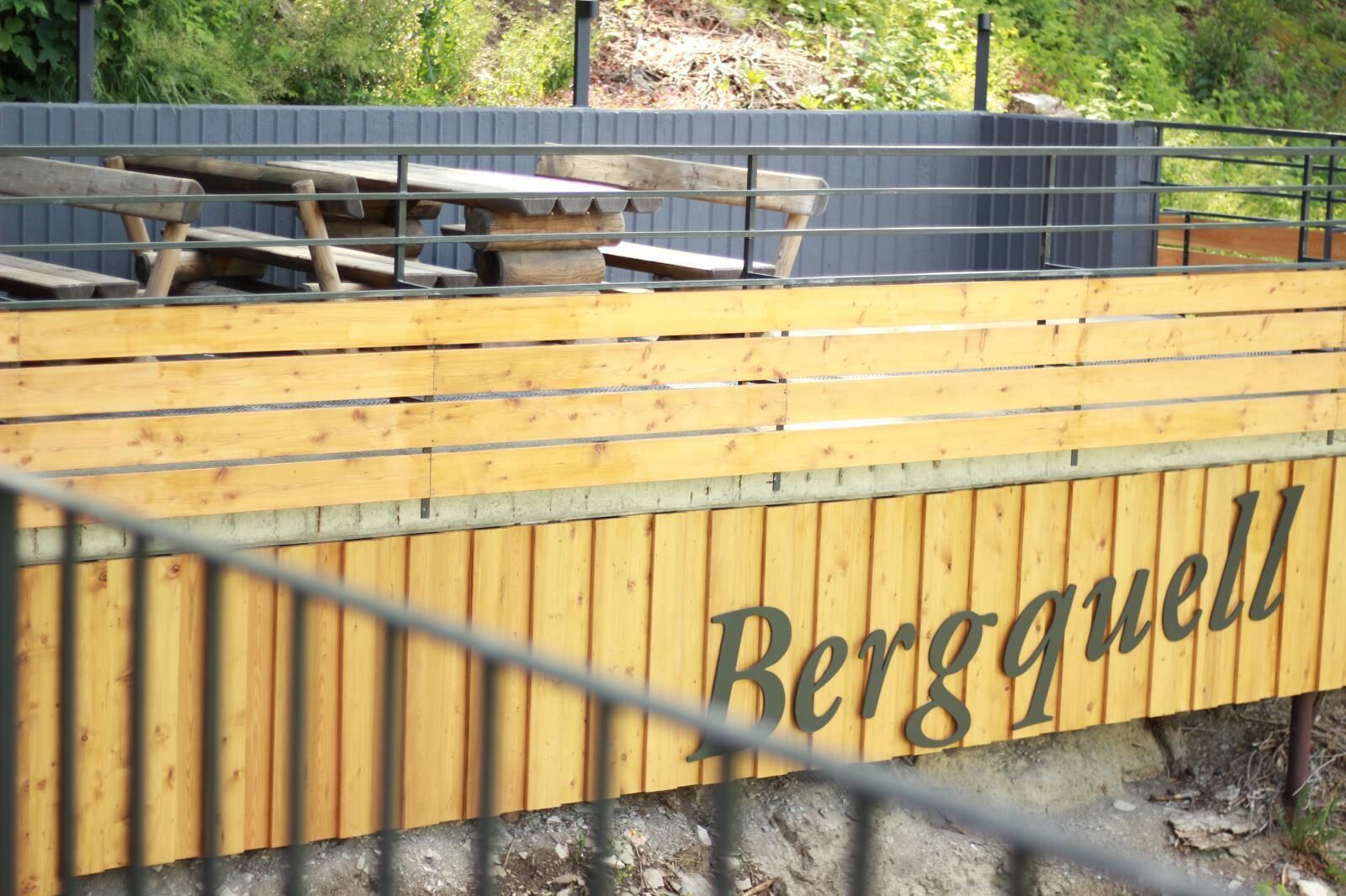 Een gebied met houten banken, met de naam 'Bergquell' op de muur.
