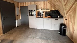 A modern kitchen with white cabinets, a built-in oven, and a coffee machine. - Bergquell Willingen App. 6 (Willingen)