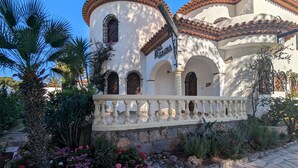 A building with a white facade, arched windows, and a balcony with balustrades. - 1 minute to the beach! Family-sized Garden and BBQ (Miami Platja)