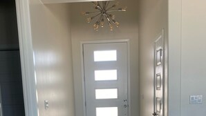 A hallway with a wooden floor, a door with rectangular windows, and a ceiling light fixture. - The Perfect Lake Havasu Lake View Pool/Spa Home getaway!!! (Lake Havasu City)