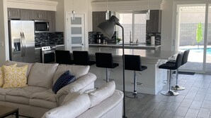 A modern kitchen with stainless steel appliances, a central island, and a dining area with bar stools. - The Perfect Lake Havasu Lake View Pool/Spa Home getaway!!! (Lake Havasu City)