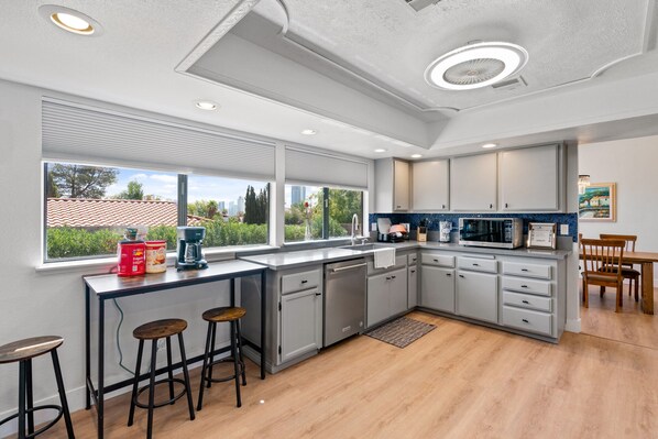 Enjoy meals in this kitchen with a dishwasher, microwave, and coffee maker, and take in the city view from the large window.