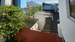 Ein modernes Gebäude mit blauer Fassade, eine Treppe, die zu einem Dach führt, und eine Bergblick in der Ferne.