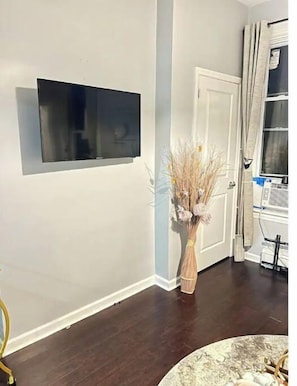 Relax in a comfortable room with a flat-screen TV and a beautiful vase with dried flowers.