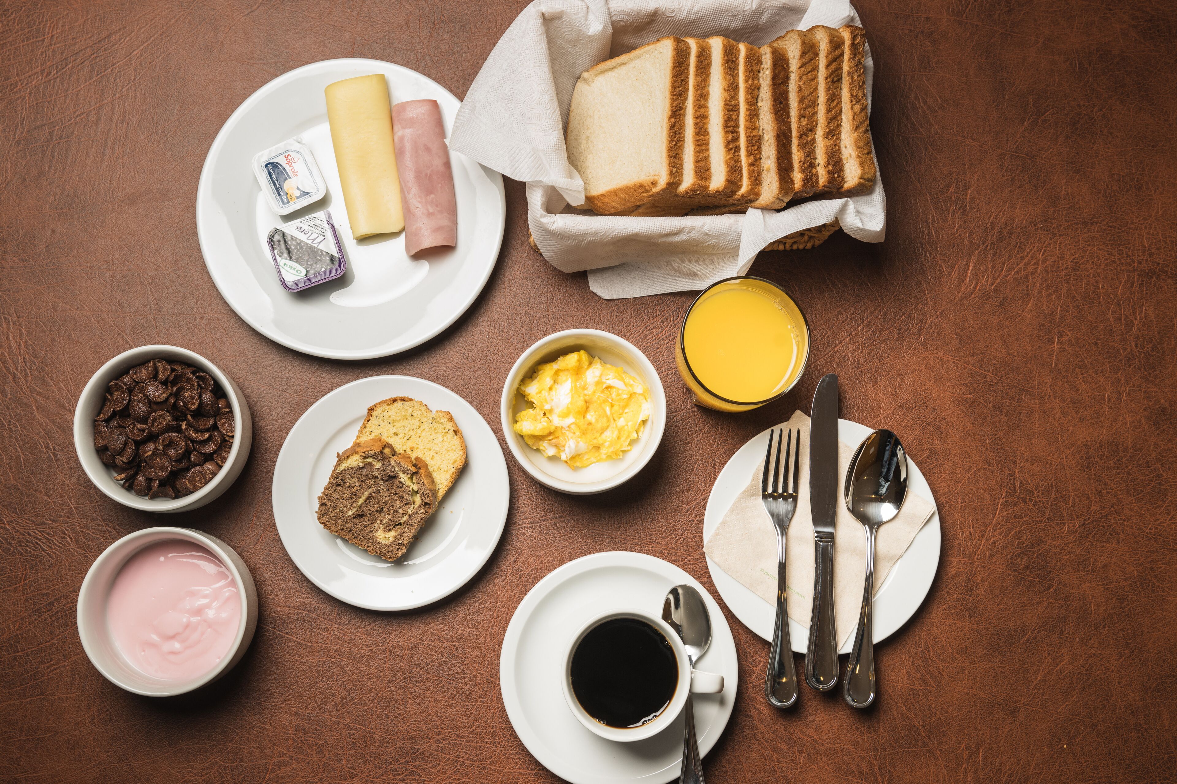 Een ontbijttafel met toast, eieren, chocolade en koffie.