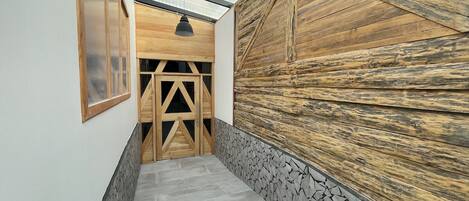 Un estrecho pasillo con techo inclinado, paredes de madera y una pared de acento de piedra.
