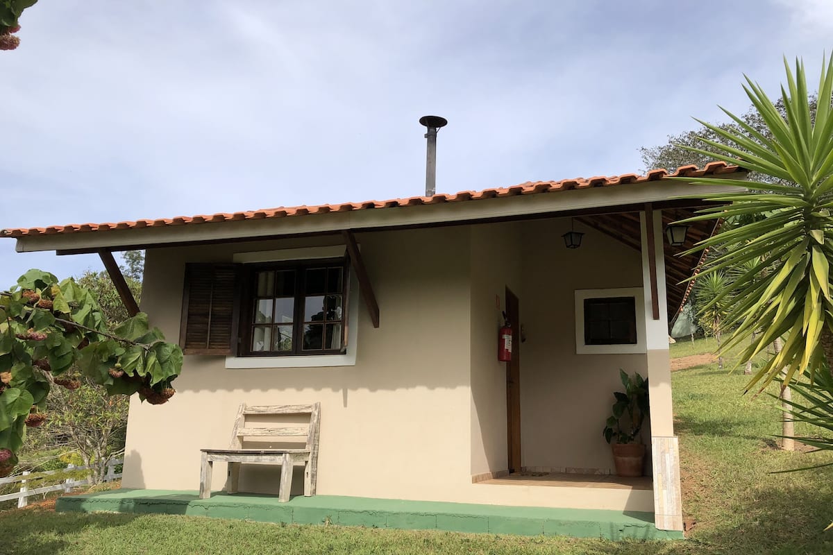 Una pequeña casa con techo de tejas, una ventana, una puerta y un pequeño porche.