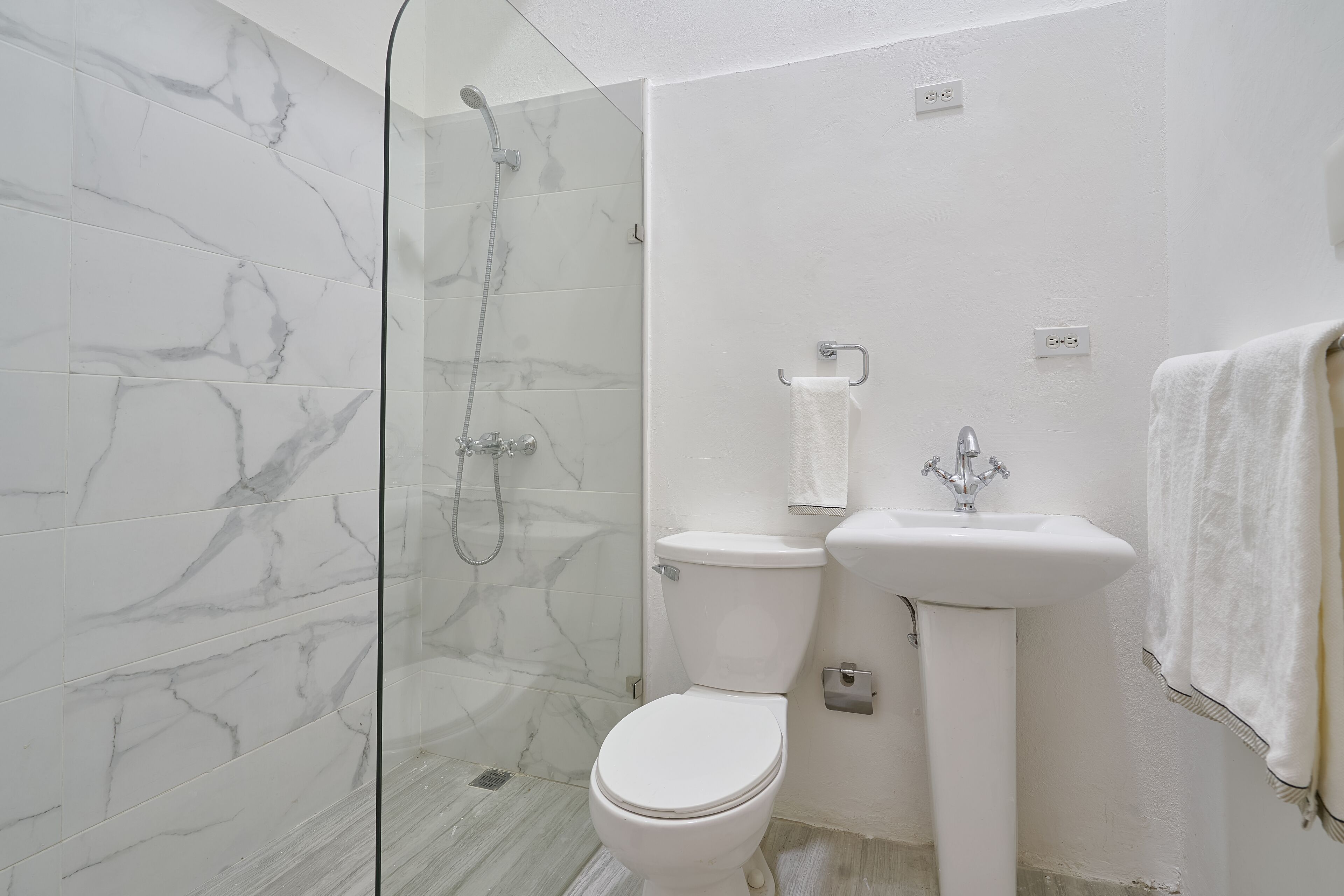 Un baño con ducha, inodoro y lavabo.