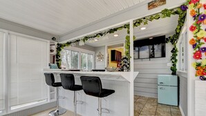 Eine Küche mit Bar, weißen Schränken und einem hellblauen Kühlschrank.