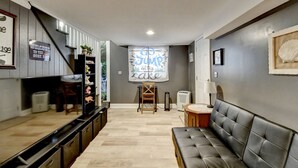 Ein modernes Wohnzimmer mit einer Couch, einem Fernseher, einer Treppe und einem Willkommensschild.