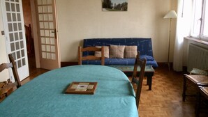 Une pièce comprenant un lit, un canapé, une chaise, une table et un tableau accroché au mur.