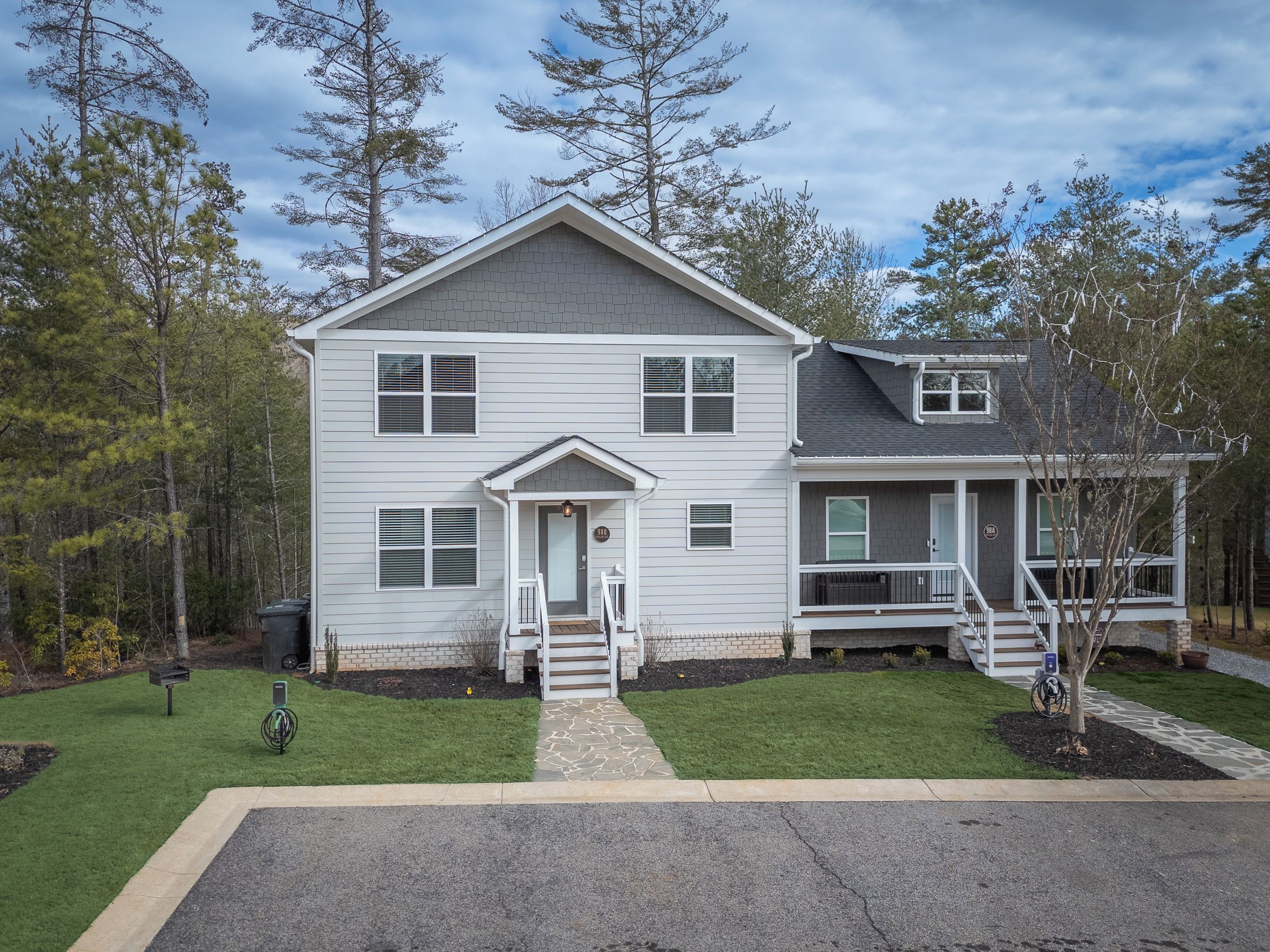 A two-story house with a front porch, a garage, and a small attached structure.