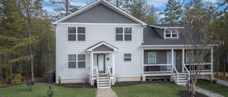 A two-story house with a front porch, a garage, and a small attached structure.