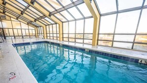 An indoor swimming pool with clear glass walls and a view of the outside. - New at Caravelle Resort - Pools - Honeymoon Suite! (Myrtle Beach)