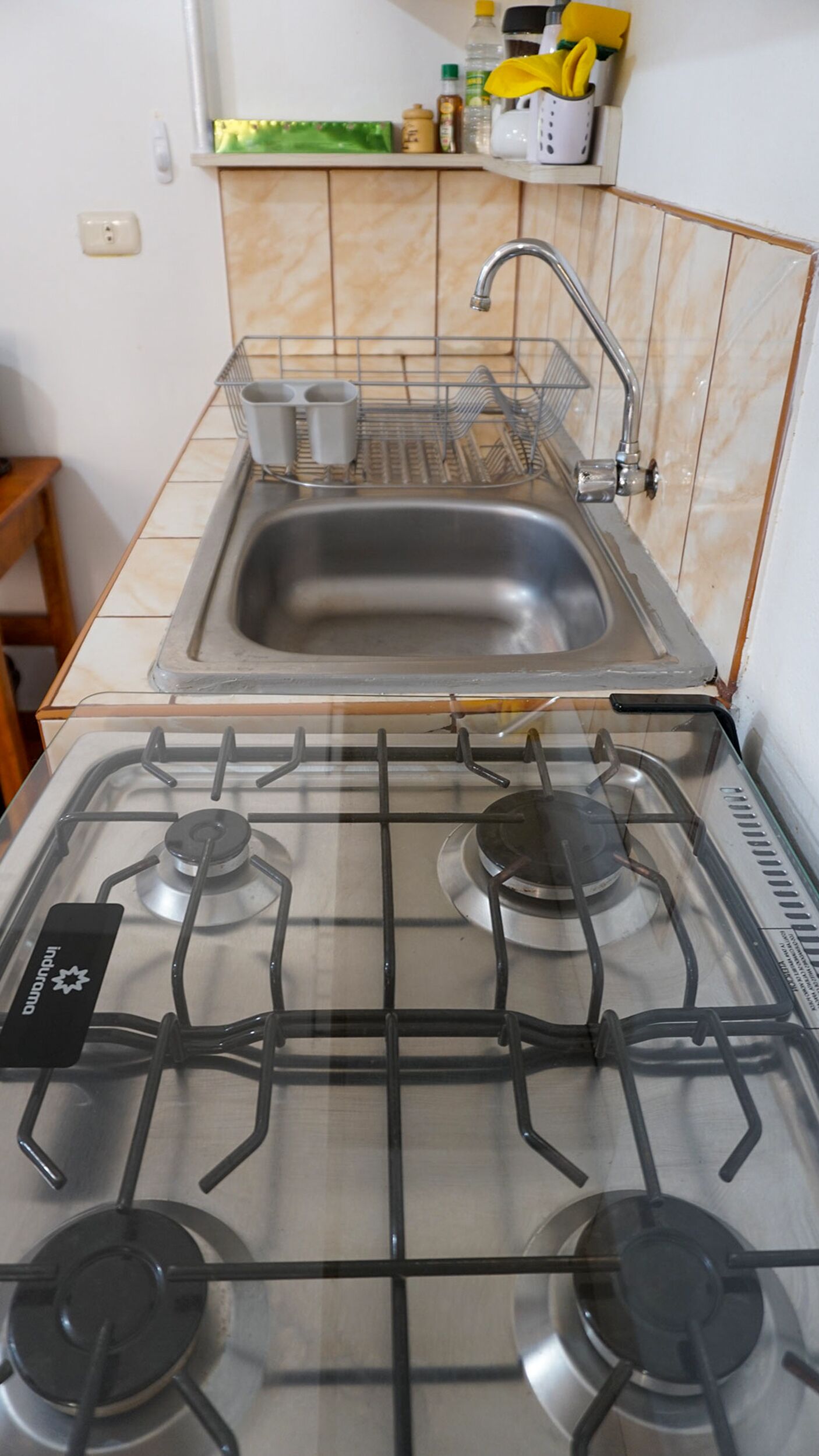 Una cucina con piano cottura a gas, lavello e ripiano.
