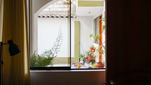 Ein Zimmer mit großem Fenster, Vorhang und Lampe.