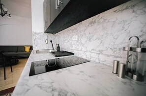 A modern kitchen with a marble countertop, a built-in sink, and a stainless steel kettle. - Historic Colonial Apt: Fast Wi-Fi, Free Parking (San Juan)