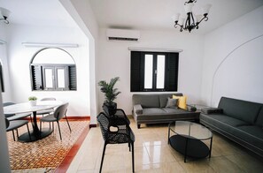 A modern living room with a dining area, a sofa set, a coffee table, and a chandelier. - Historic Colonial Apt: Fast Wi-Fi, Free Parking (San Juan)