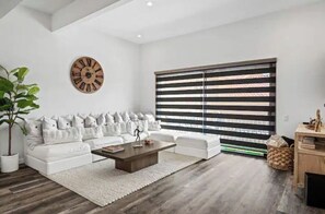 Relax in this stylish living room with a sofa set, coffee table, and large wall clock.