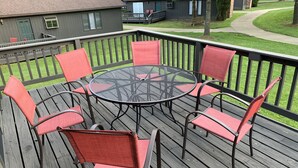 A deck with a round table and six chairs. - The Pines of Apple Valley, 31 Beautiful Vacation Condos. (Howard)