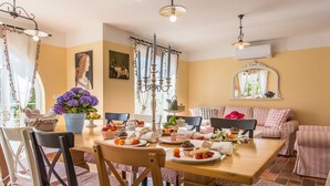A dining area with a wooden table set for a meal, surrounded by chairs. - Villa LEMON BELLISSIMA (Ljutići)