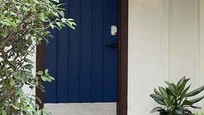 A blue door with a keypad lock, a black lantern-style light, and a potted plant on the porch. - Townhome Medical Ctr/Six Flags/La Cantera/Rim (San Antonio)