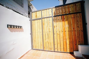 A gated entrance with a wooden fence and a metal gate. - Colonial Apartment with Generator, Free Parking, (San Juan)