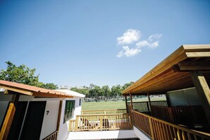 A building with a balcony overlooking a grassy area. - Colonial Apartment with Generator, Free Parking, (San Juan)