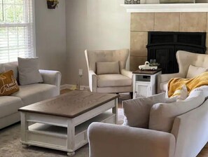 Cozy living room with a fireplace, sofa, and armchair.