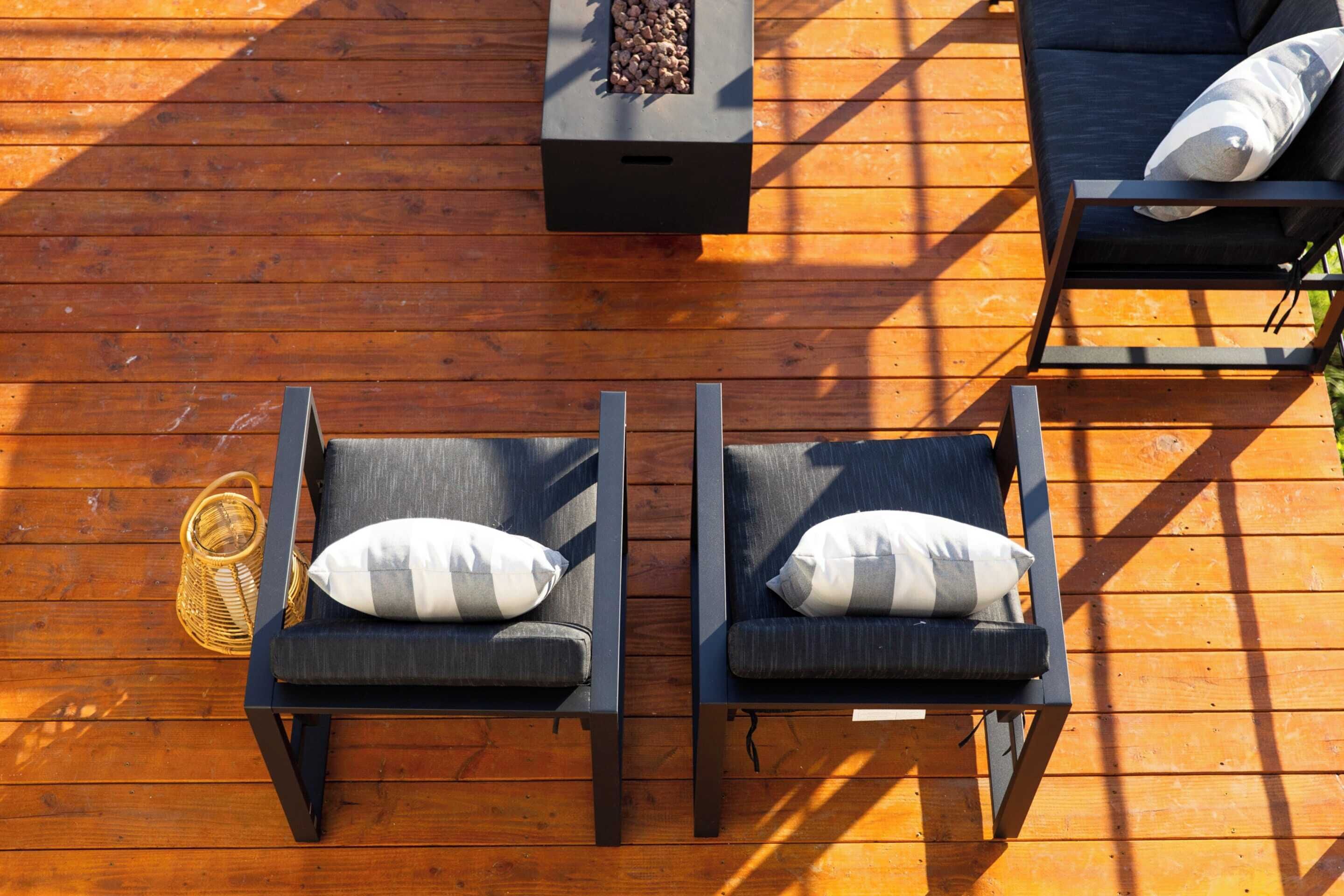 Une terrasse extérieure avec deux chaises longues, une petite table et un panier en osier.