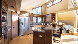 A modern kitchen with wooden cabinets, stainless steel appliances, and a large island.