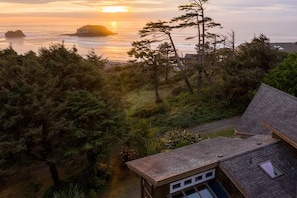 A coastal house with a view of the ocean and a sunset.