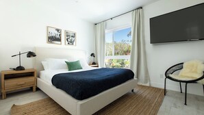 A bedroom with a bed, bedside tables, a chair, a TV, and a window with curtains. - Avalon I by AvantStay Contemporary San Diego Condo w Large Balcony (San Diego)