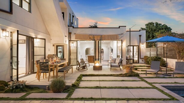 A modern outdoor patio with a pool, seating areas, and a dining setup. - Vista Del Mar by Avantstay Stunning Spanish Inspired Home w/ Pool, Hot Tub & Rooftop Patio (La Jolla)