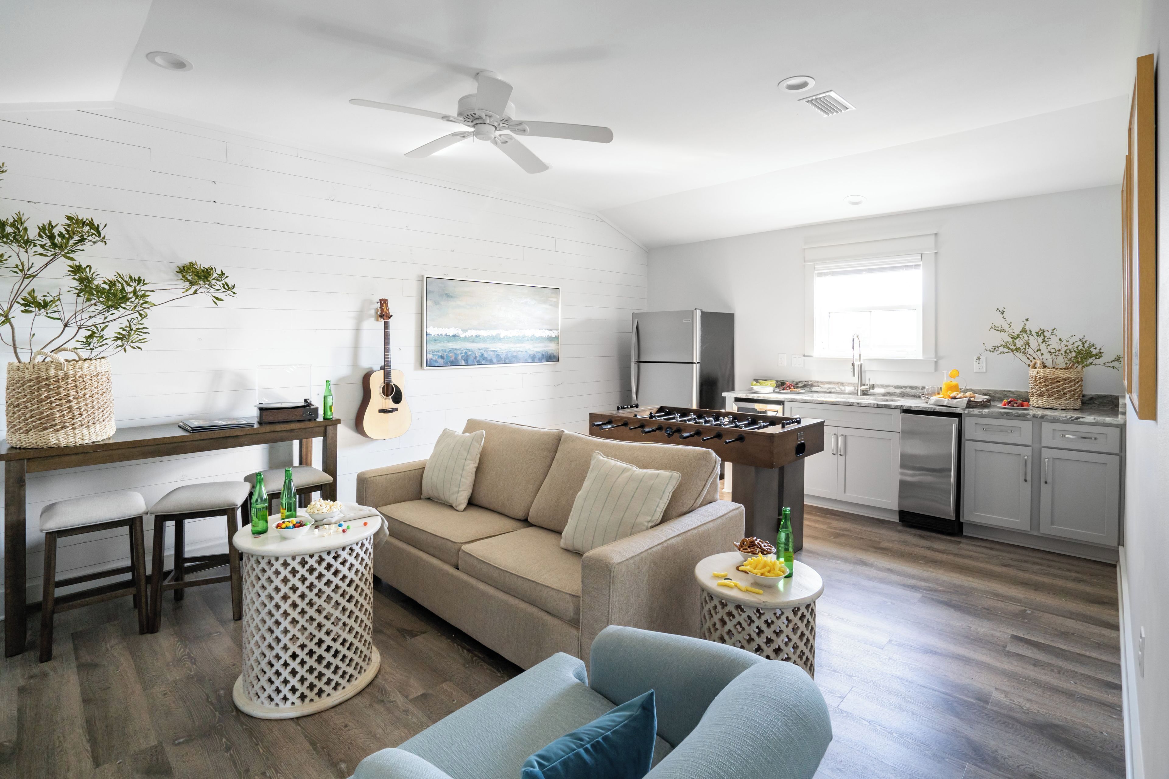 A modern living room with a sofa, coffee table, and a guitar.