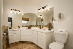 A modern bathroom with a curved vanity, double sinks, and a toilet. - Petit Sahara by Avantstay Desert Escape w/ Pool, Outdoor Dining & Table Tennis! (Indio)