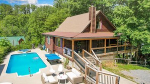 Eine Hütte mit Swimmingpool, Sitzgelegenheit im Freien und einer Terrasse.