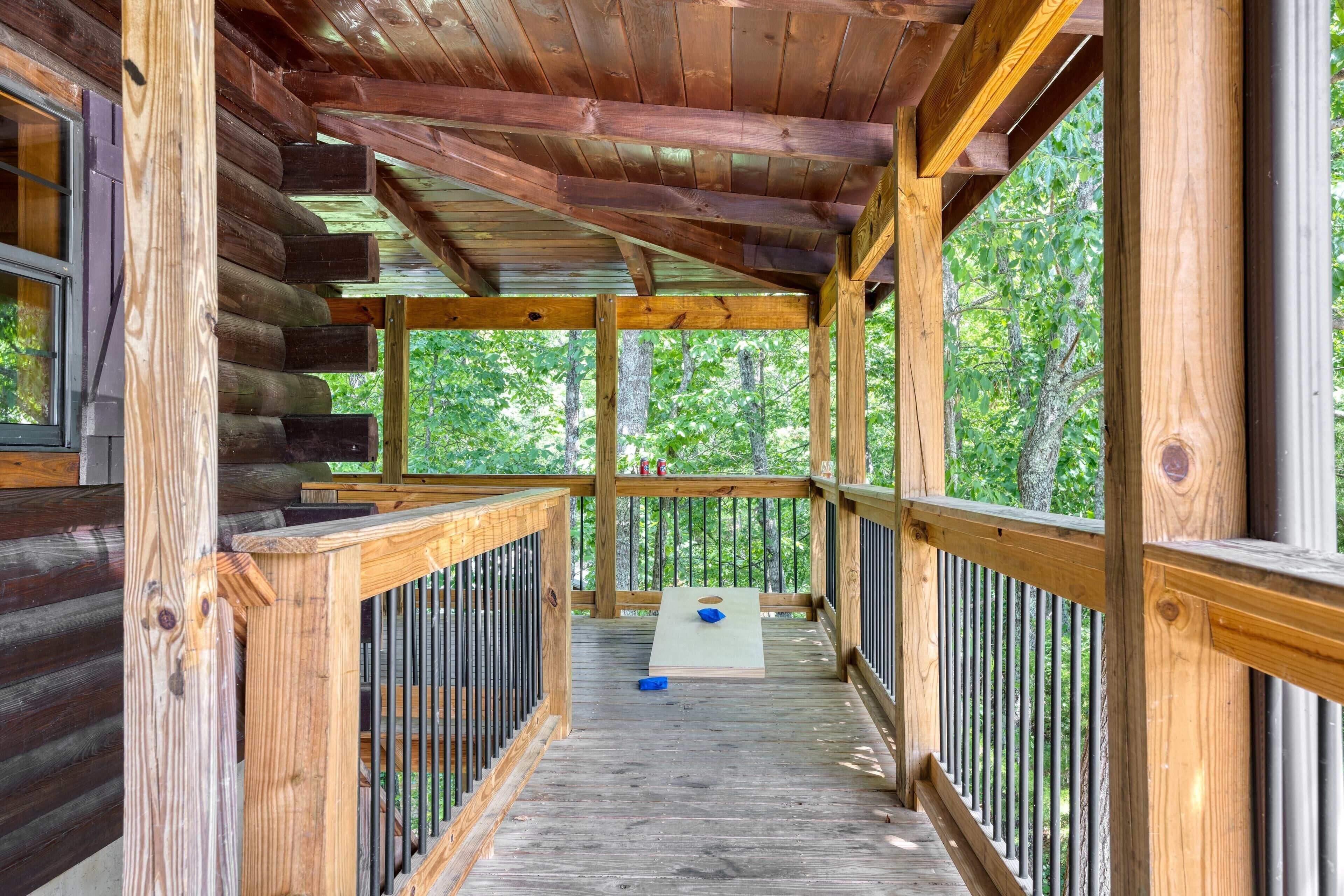 A wooden deck with a view of trees, a table, and a blue object on the floor.